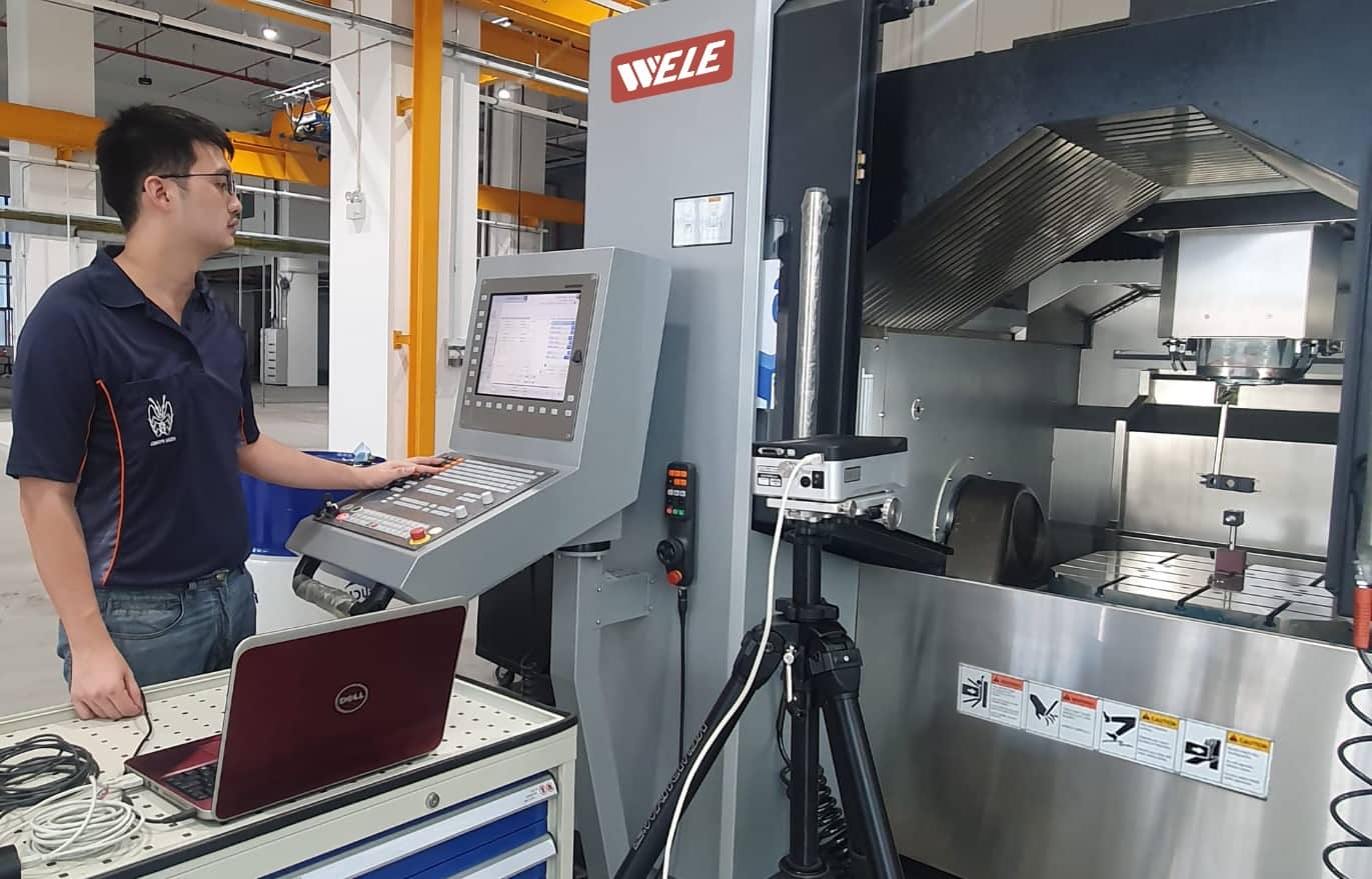 Technician operating CNC machine at Hsiu Fong Machinery workshop, showcasing advanced machining services and equipment in Singapore